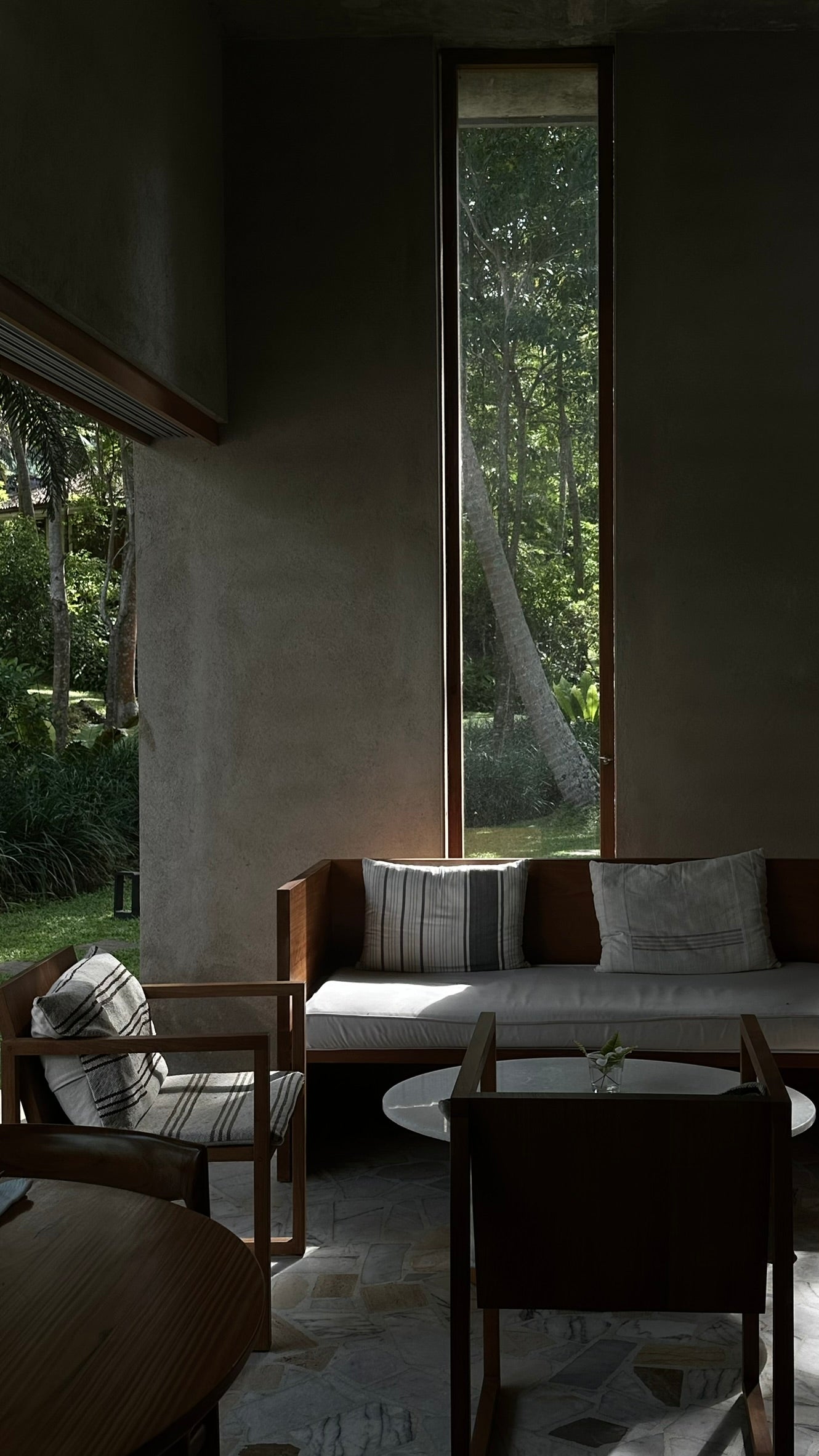 Modern living room with a large window overlooking a forest.
